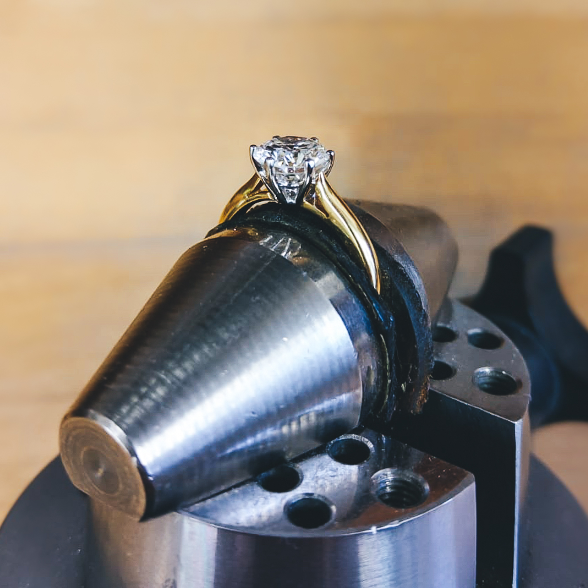 Claw-set diamond ring on jewellery workbench